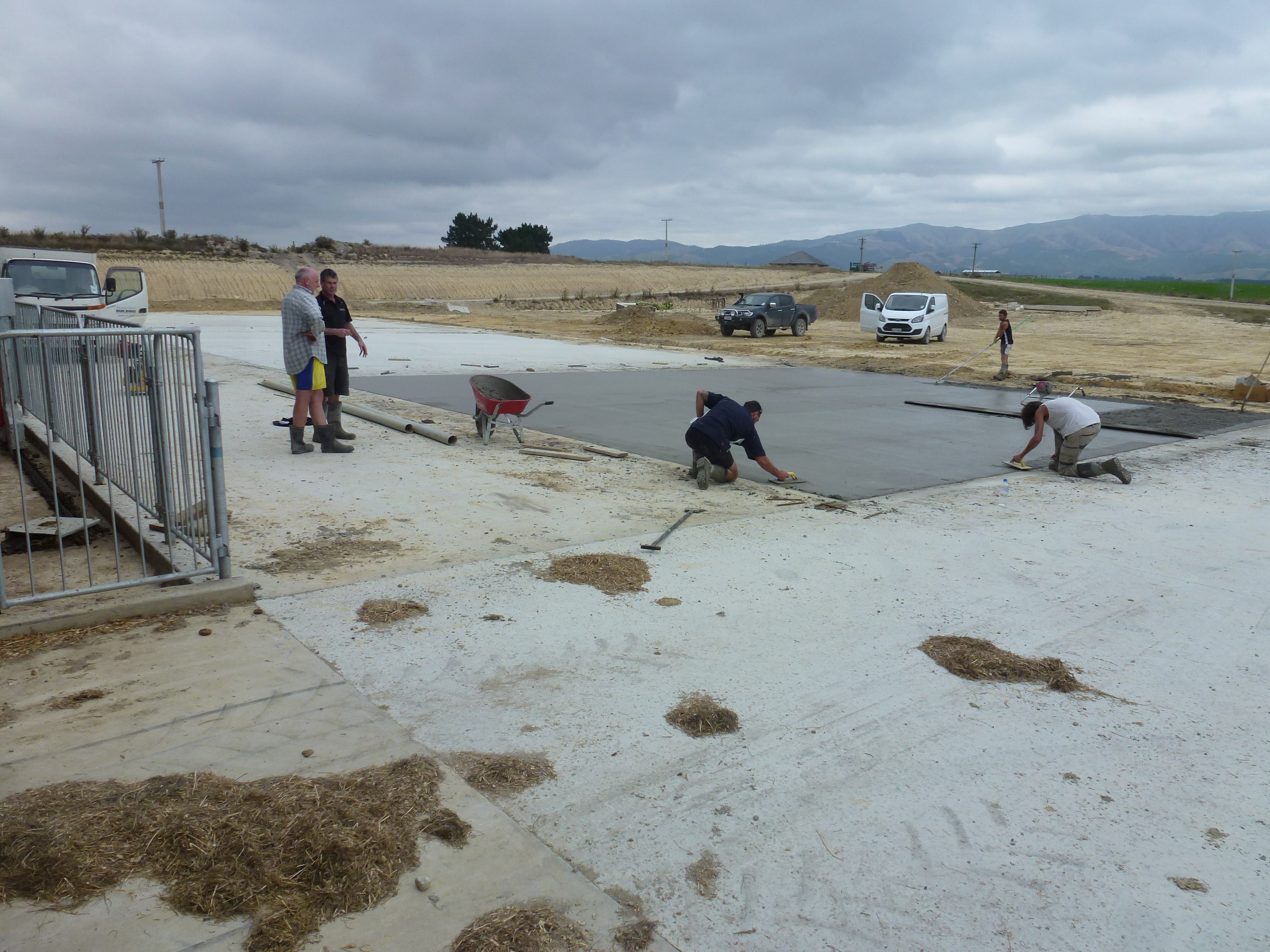 5 workers place fibre concrete on a building site in New Zealand